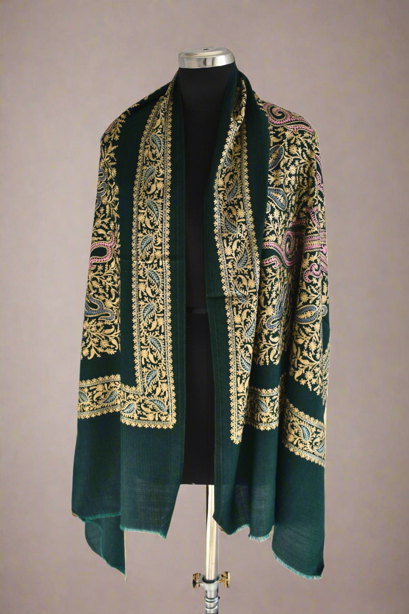 Green embroidered shawl on a mannequin against a white background