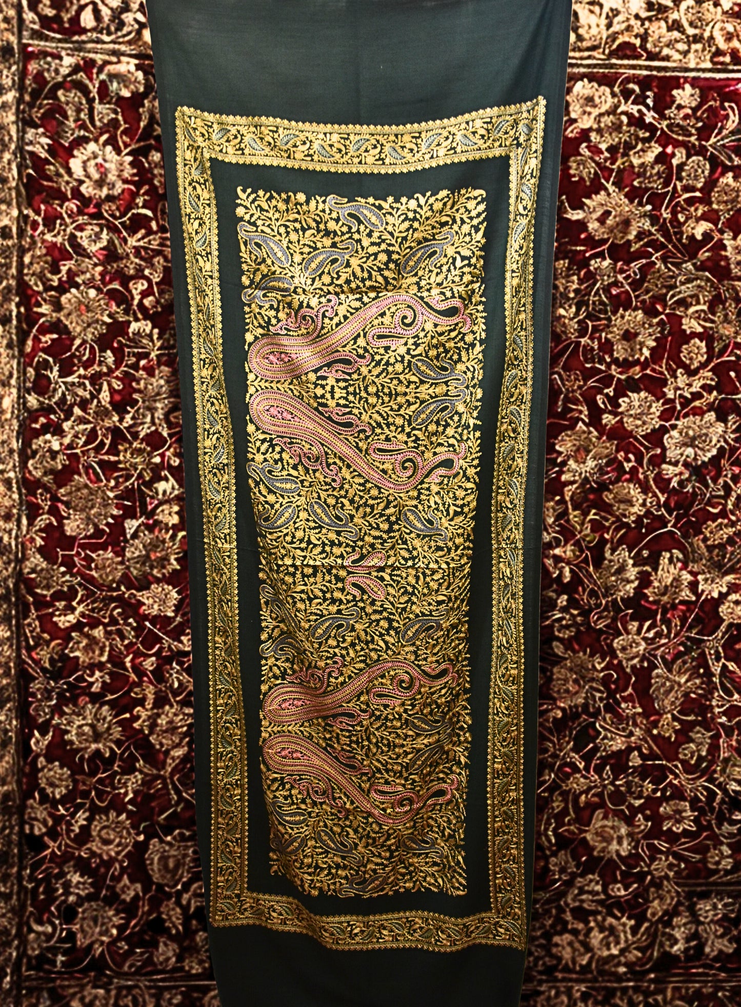 Decorative stole with intricate gold embroidery on a red carpet