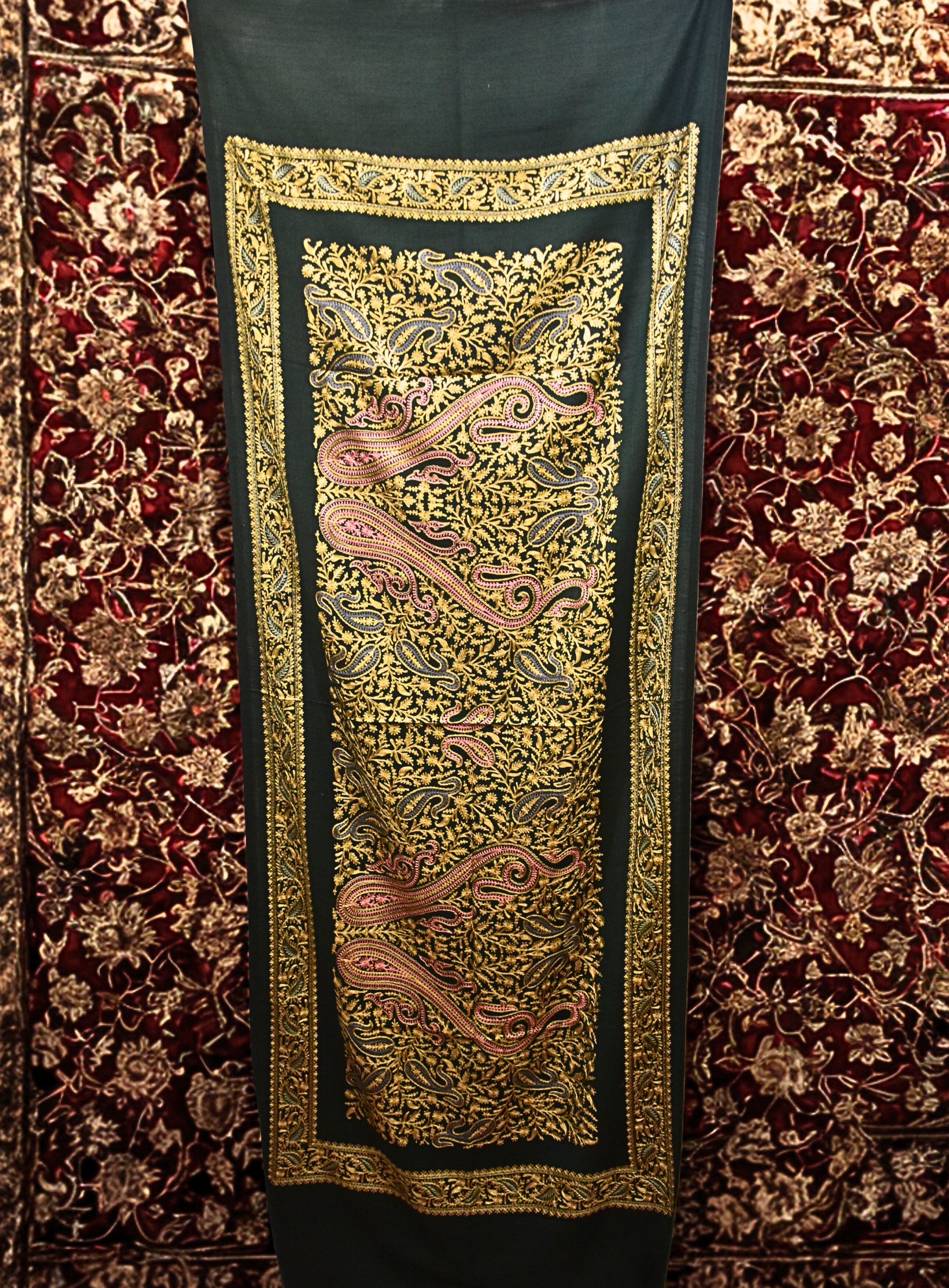 Decorative stole with intricate gold embroidery on a red carpet