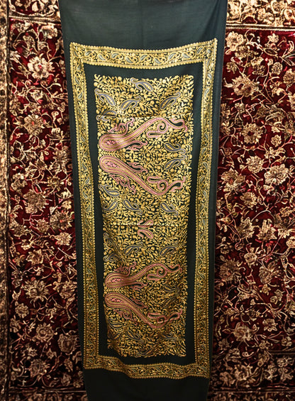 Decorative stole with intricate gold embroidery on a red carpet