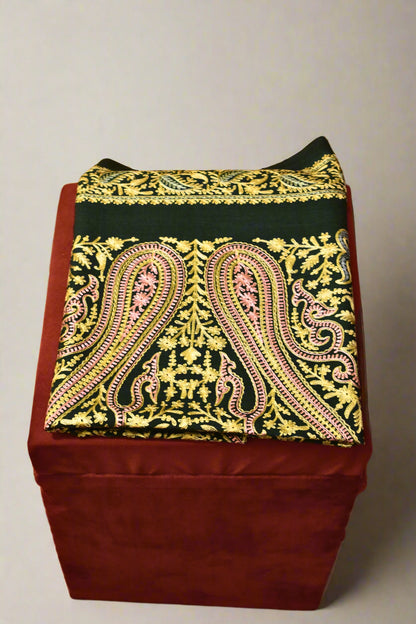 Decorative stole with a patterned cover on a wooden floor.