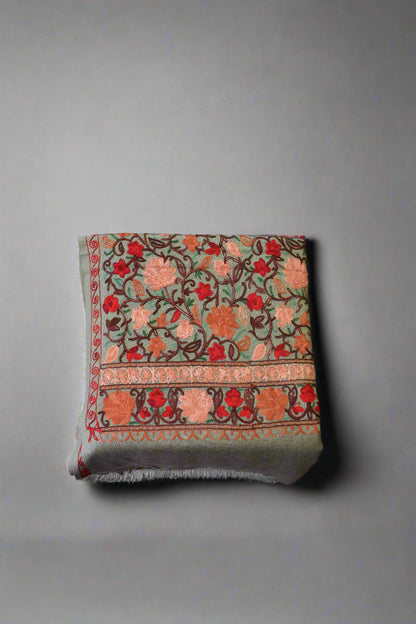 Decorative floral-patterned aari stole on a wooden floor